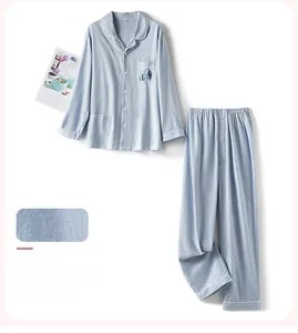 Dettaglio del pigiama in cotone blu soleggiato con bordino bianco e ricamo fine