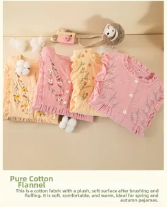 Detail of floral embroidery and ruffled edges on folded cotton flannel kids pajamas