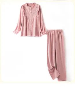 Detail of plum pink cotton pajamas featuring delicate floral embroidery and ruffled edges