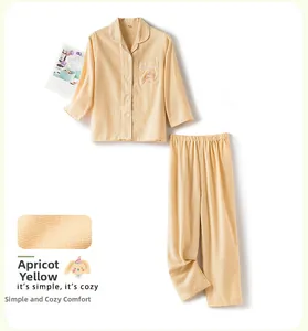 Détail de pyjama enfant en coton jaune abricot avec broderie et texture de tissu doux
