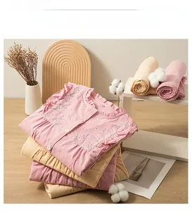 Detail of floral embroidery and ruffled cotton fabric on pink and beige loungewear