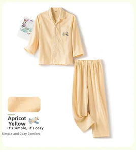 Détails de broderie avion et texture gaufrée sur cet ensemble de pyjama enfant abricot
