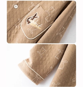 Detail of brown quilted pajama fabric with diamond texture and cute rabbit embroidery
