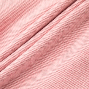 Dettaglio del tessuto del pigiama in flanella di cotone rosa con texture spazzolata