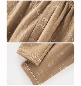 Detail of brown quilted pajama pants featuring rabbit embroidery and elastic waistband
