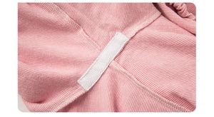 Close-up of pink waffle fabric featuring reinforced herringbone tape and neat inner seams