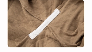Detailed macro view of brown quilted fabric interior with white herringbone reinforcing tape
