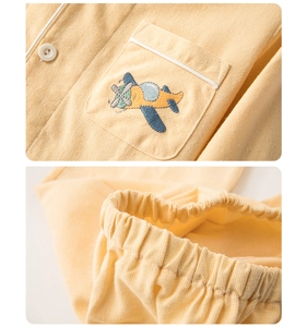 Détail de pyjama enfant avec broderie avion sur la poche et taille élastique douce