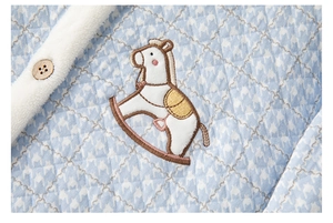 Detail of quilted blue houndstooth fabric with rocking horse embroidery and wool collar