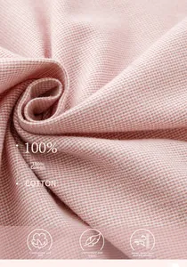 Gros plan du tissu 100% coton rose doux montrant le tissage fin et la texture