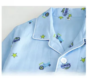 Détail de pyjama bleu clair pour garçons en coton avec liseré et camions de dessin