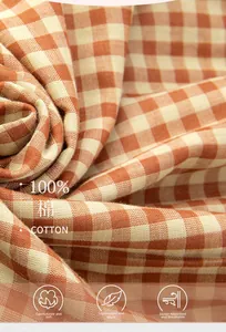 Macro shot of 100% cotton double-layer gauze fabric with orange and white grid texture