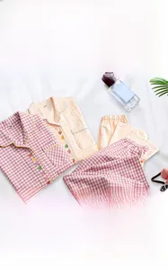 Détail de pyjamas en coton à carreaux rouges et jaunes avec broderie de fruits sur le devant