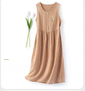 Detail of caramel gingham sleeveless cotton dress with daisy embroidery and wood buttons