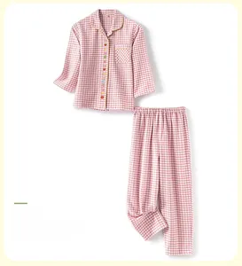 Détail d'un pyjama enfant à carreaux roses avec boutons fruits et texture coton douce