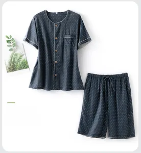Détails d'un pyjama en coton bleu marine à pois avec boutons en bois et liseré blanc