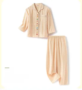 Détail du pyjama à carreaux jaunes avec boutons décoratifs aux motifs de fruits
