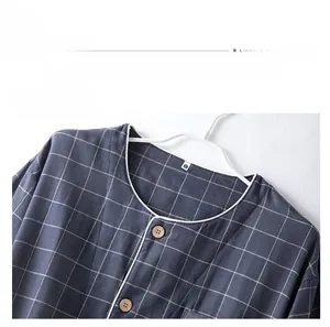 Détail de pyjama en coton à carreaux bleu marine avec boutons en bois et liseré blanc
