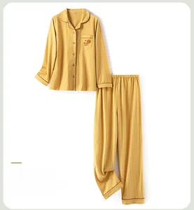 Detail of yellow striped cotton pajama set featuring a cute squirrel embroidery on the pocket