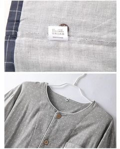 Détail d'un pyjama en coton gris avec boutons en bois et étiquette de lavage