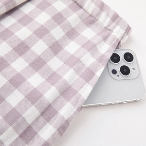 Purple and white checkered cotton pajamas showing a functional side pocket with a phone