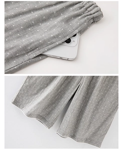 Détail du pantalon en coton gris à pois avec taille élastique, poches et liseré blanc