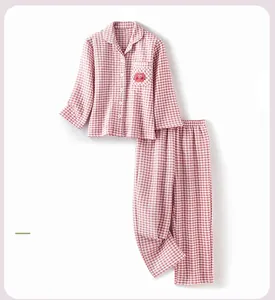 Close-up of pink checkered pajama set featuring cute red apple embroidery on soft fabric