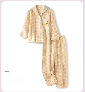 Detail of yellow checkered children's pajamas featuring cute banana embroidery and buttons