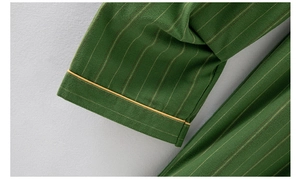 Detail of green striped cotton pajama sleeve with yellow piped cuff and soft texture