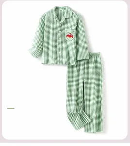 Detail view of green plaid kids pajamas with cute car embroidery on chest pocket