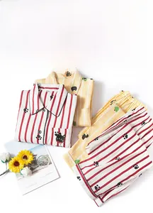 Flat lay of striped cotton pajamas featuring a cat pocket detail and button-down collar