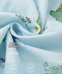 Gros plan sur tissu 100% coton bleu clair avec motif de dinosaure vert mignon