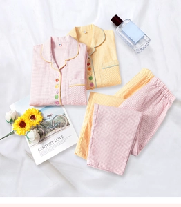 Détail de pyjamas en coton à carreaux pour enfants avec boutons en forme de fruits colorés