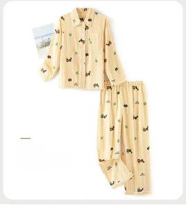Detail of yellow striped cotton pajama set featuring cartoon black cat and forest patterns