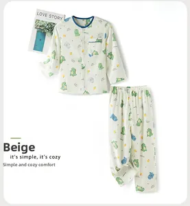 Détail de pyjama beige en coton pour enfants avec imprimé dinosaure et passepoil bleu