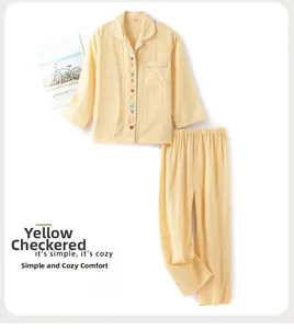 Détail du pyjama à carreaux jaunes avec boutons de fruits colorés et liseré vert