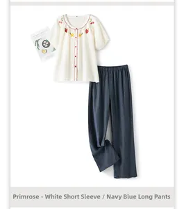 Détail du pyjama en coton blanc avec liseré rouge et broderie de cerises