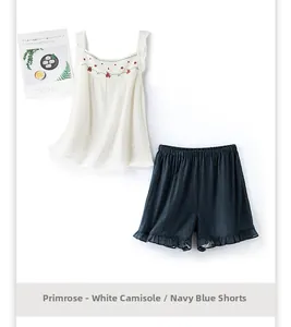 Détail d'un pyjama en coton avec broderie florale sur le haut et short bleu marine