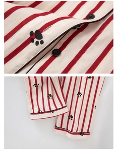 Detailed view of red striped cotton pajamas with black paw prints and button-down collar