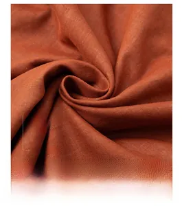 Detailed macro view of 100% cotton fabric showing soft woven texture and orange hue