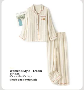 Flat lay of women's striped cotton pajamas set with cute puppy embroidery and orange trim