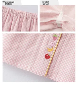 Détail d'un pyjama à carreaux roses avec taille élastique et broderies de fruits mignonnes