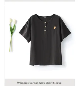 Detail of charcoal grey cotton pajama top with wood buttons and floral embroidery