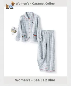 Detail der blauen Karo-Baumwoll-Pyjamas mit Hunde-Stickerei und roter Paspelierung