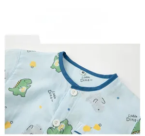 Détail du haut de pyjama en coton bleu clair pour enfants avec imprimé dinosaure