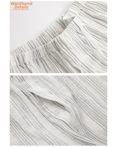 Detail of grey vertical striped cotton pajama pants with elastic waistband and buttoned pocket