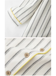 Close-up of striped cotton pajama sleeve and wooden button with yellow piping trim