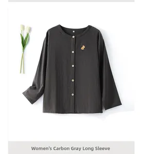 Detail of charcoal grey cotton pajama top with hamster embroidery and wood-textured buttons