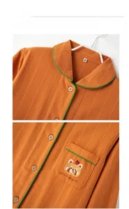 Detail of orange striped pajamas featuring a green piping collar and cute bear embroidery