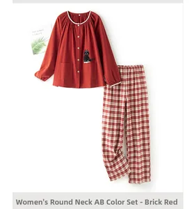 Close-up of brick red pajama top with lace trim and cute black cat embroidery detail